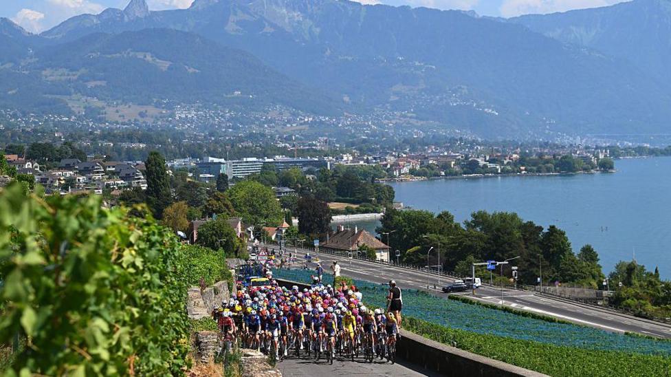  A general view of Lorena Wiebes of Netherlands and Team SD Worx - Protime - Yellow leader jersey and the peloton passing through a vineyards landscape in Laussane