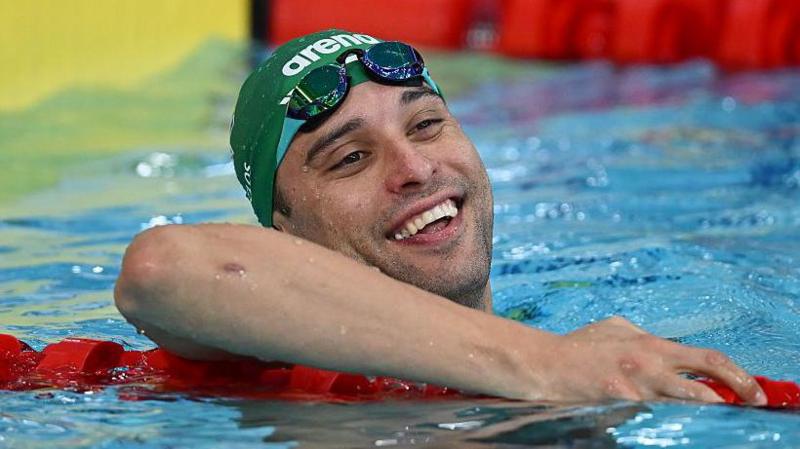 Chad le Clos smiles while holding a lane rope in the swimming pool at Tollcross