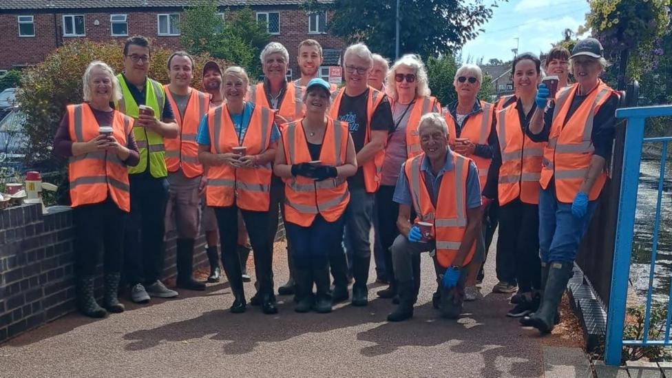 Syston Community Flood Group volunteers pose for a picture in orange high viz
