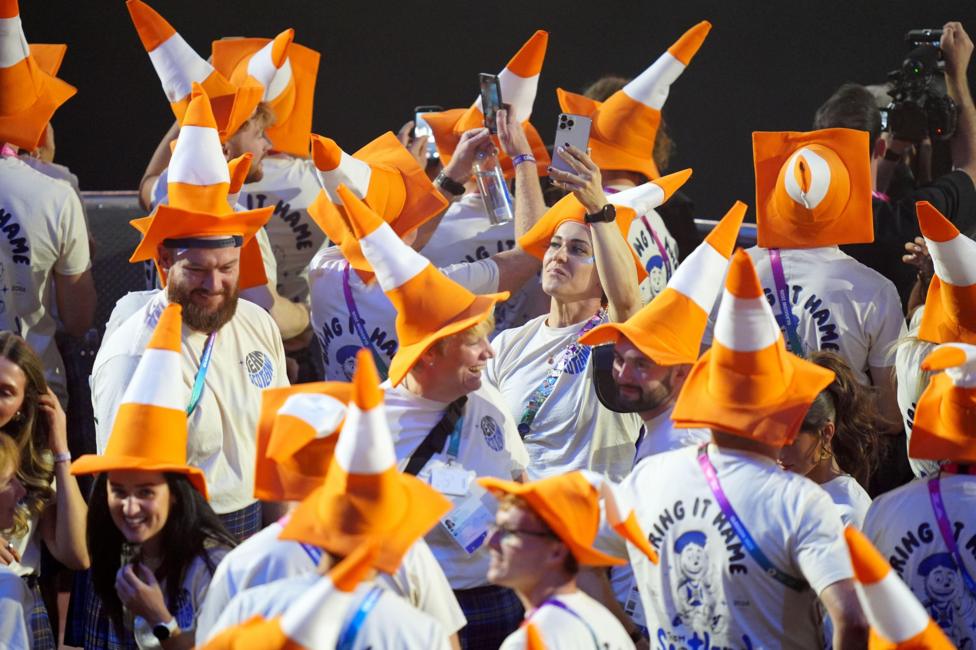 A crowd of people in T-shirts and traffic cones on their heads.