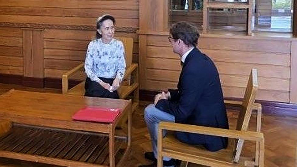 Former Myanmar president Aung San Suu Kyi talks to an official from the International Committee of the Red Cross