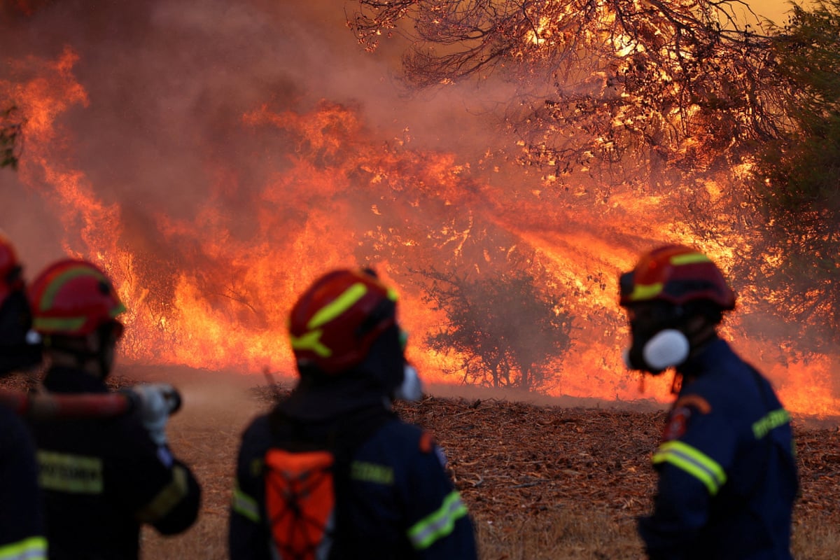 Firefighters battle a wildfire near the village Agia Paraskevi, Greece, on 2 August