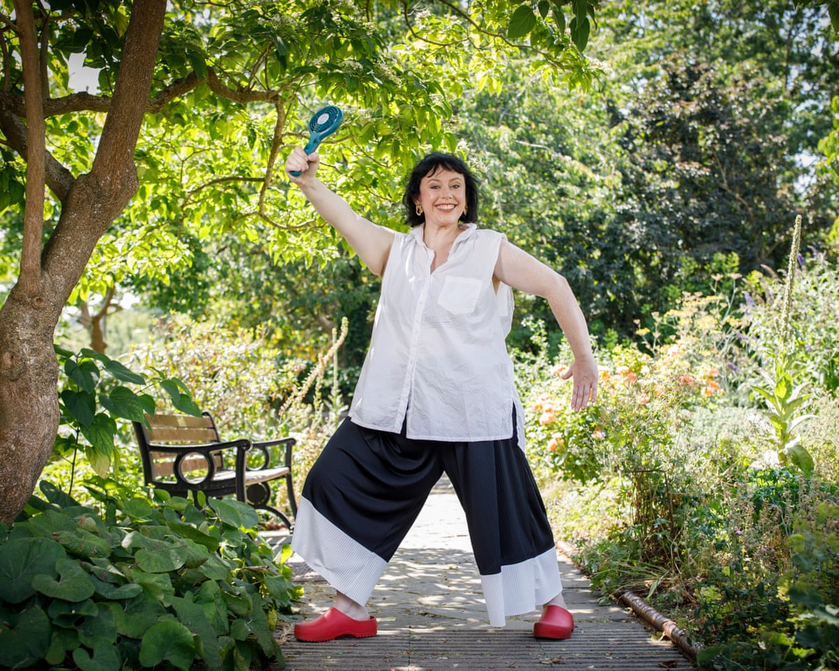 Amy Annette photographed in Brockwell Park, London, 16 July 2026, with her arms bare and holding a small portable fan up in the air