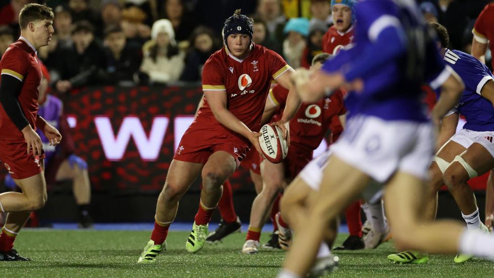 Tom Howe runs with the ball in both hands for Wales Under-20s against France