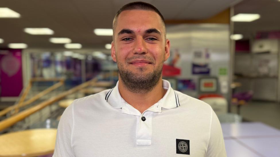 Head and shoulders shot of Andrii Lutsyk. He has cropped hair, a well-cropped beard and is wearing a white polo shirt