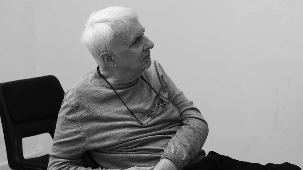 A black and white image of a man with white hair