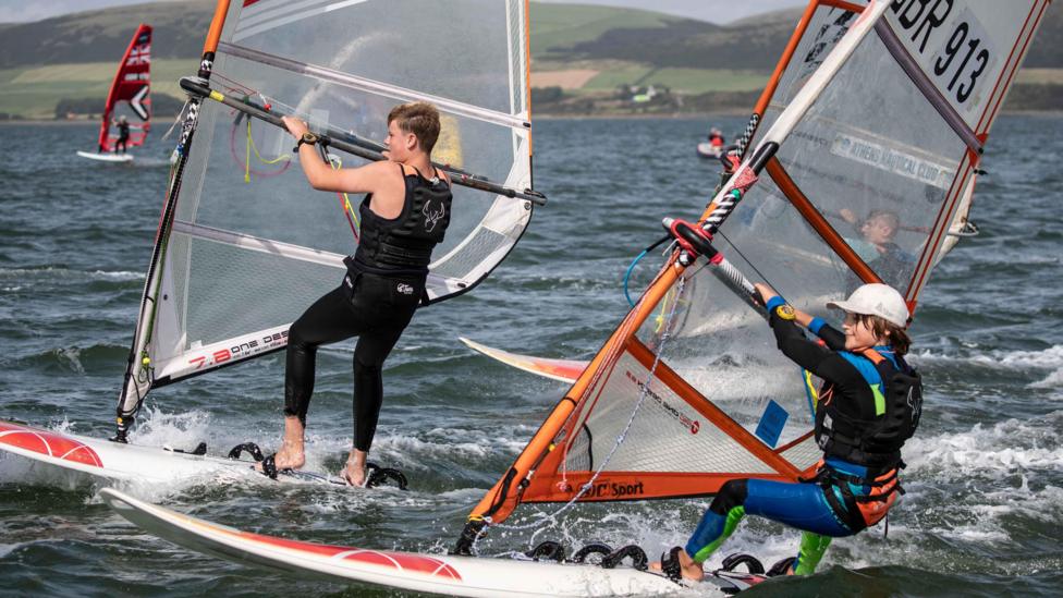 Two people on windsurfing boards in the bay at Loch Ryan