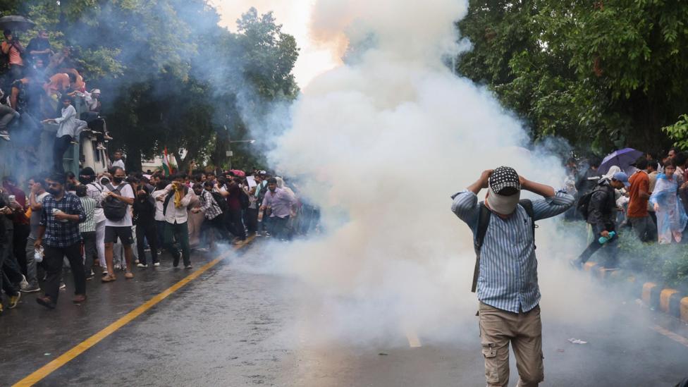 A person walking away as Indian security personnel use tear gas and lathi charge as they attempt to stop Cockroach Janta Party's(CJP) supporters during a march toward the Parliament in New Delhi, India, 20 July 2026.
