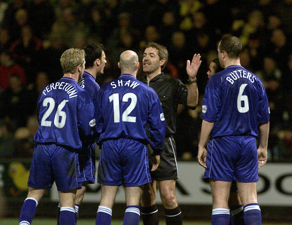 Several Gillingham players remonstrate with the referee Steve Baines.