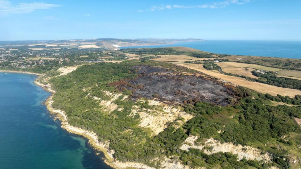 An aerial shot showing the burnt heathland as it approached the cliff edge