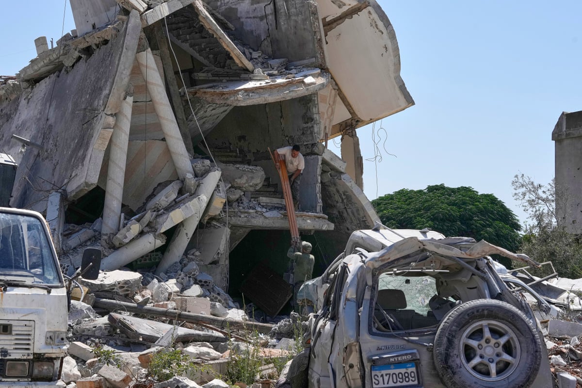 Men remove debris from their destroyed house in Zawtar al-Gharbieh.