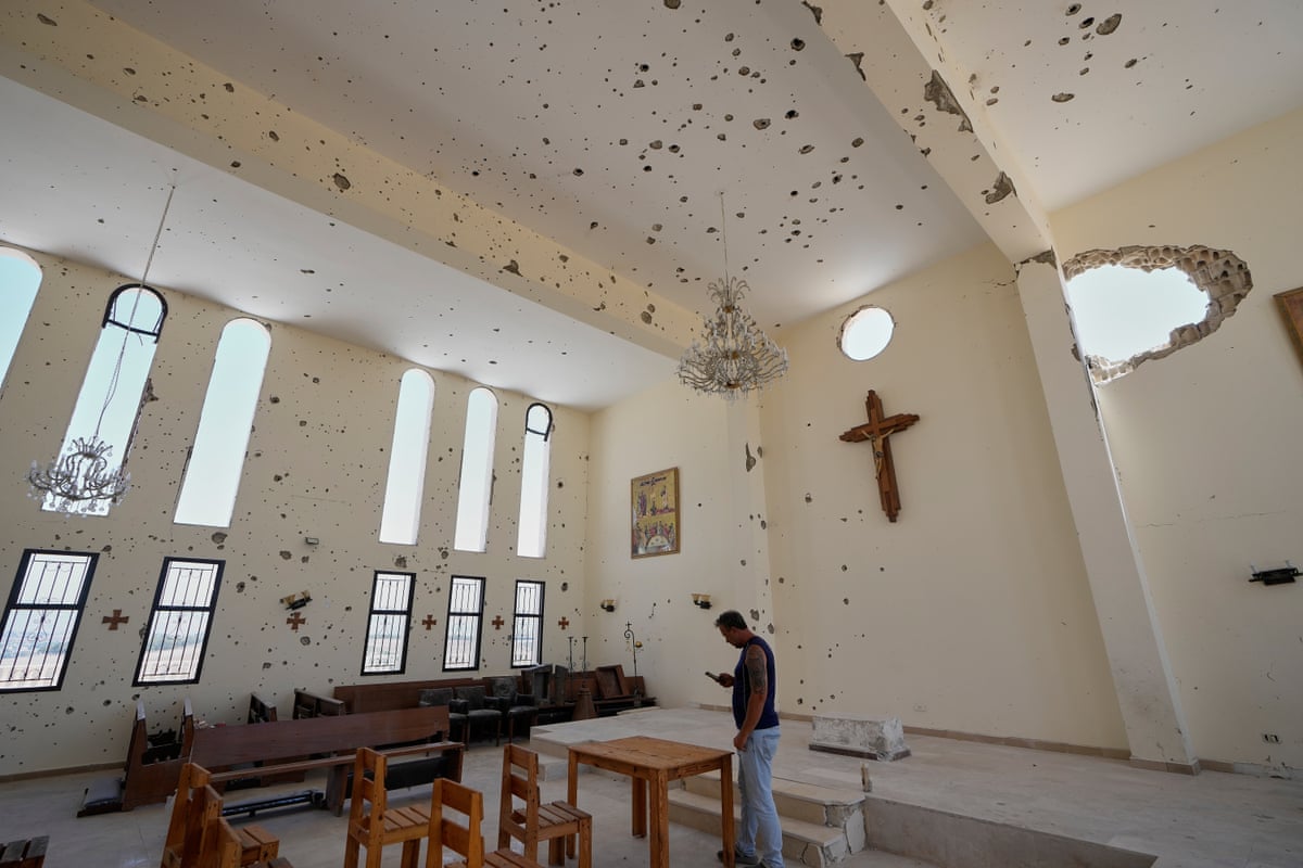 A man stands inside a damaged church.