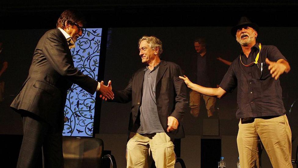 A picture of Amitabh Bachchan, Robert De Niro and Tarun Tejpal on a black stage at a conference in India's Goa, 2013