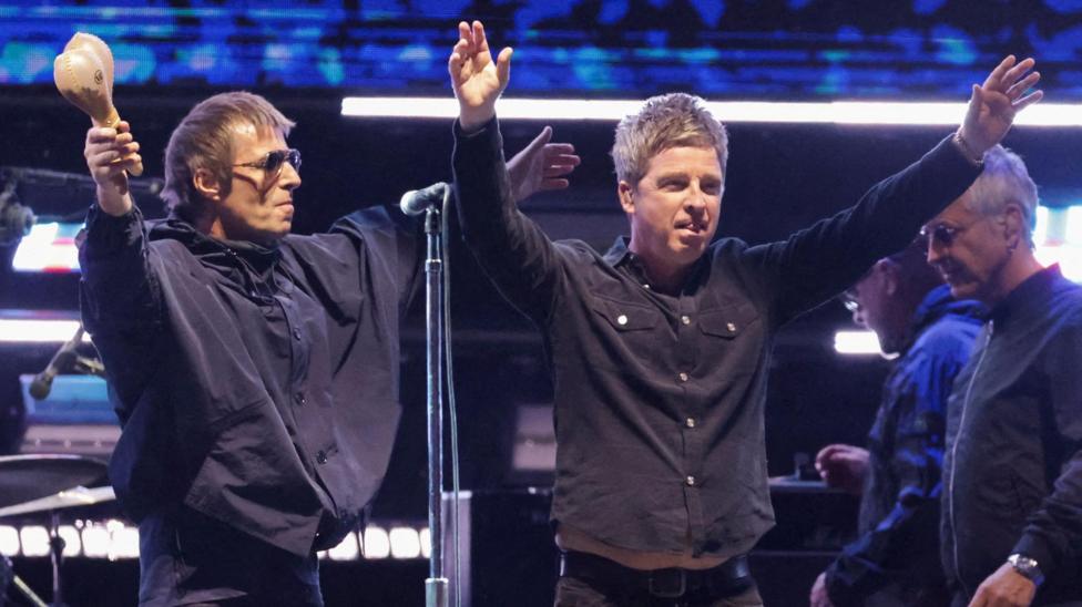 Liam Gallagher and Noel Gallagher of Oasis receive the applause of fans while on stage together at the Rose Bowl Stadium in Pasadena, California in September 2025