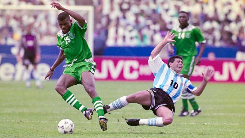 Diego Maradona, playing for the Argentina Men's football team against Nigeria in 1994 in mid air falling to the ground following a challenge.