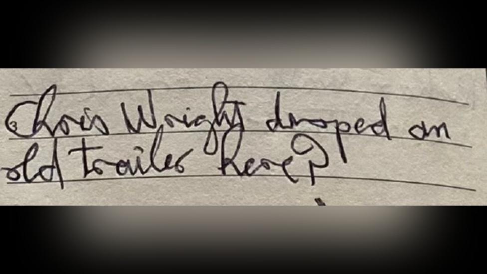 A close-up photograph of a lined notebook page shows a handwritten note in cursive ink that appears to read: “Chris Wright dropped an old trailer here?