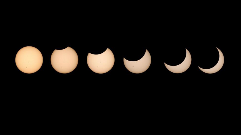 The progression of a solar eclipse - six yellow circles against a black backdrop slowly being more obscured.