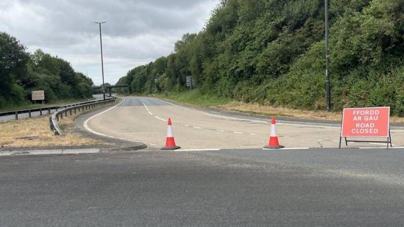 A dual carriageway with a red sign that says road closed.