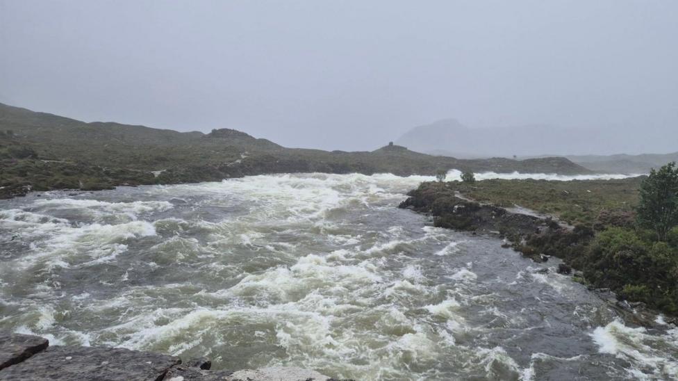 A fast flowing section of water under a gun metal grey sky.