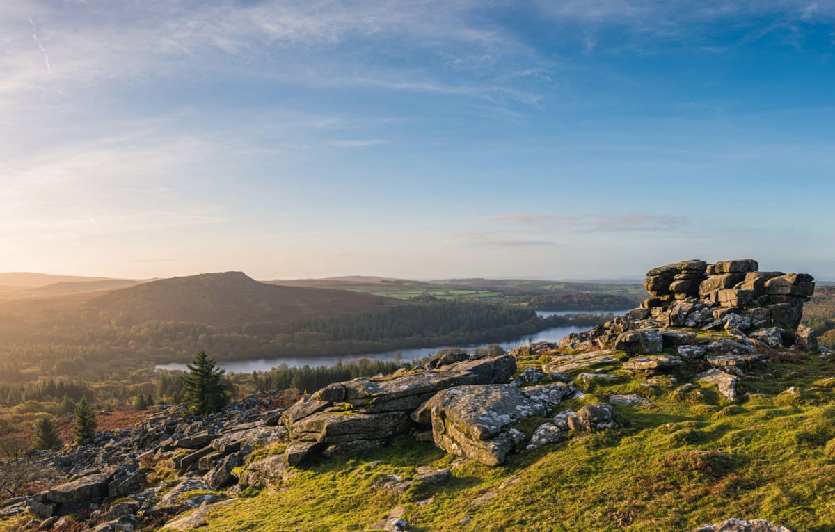 Distant river running through a valley in moorland with rocky tors