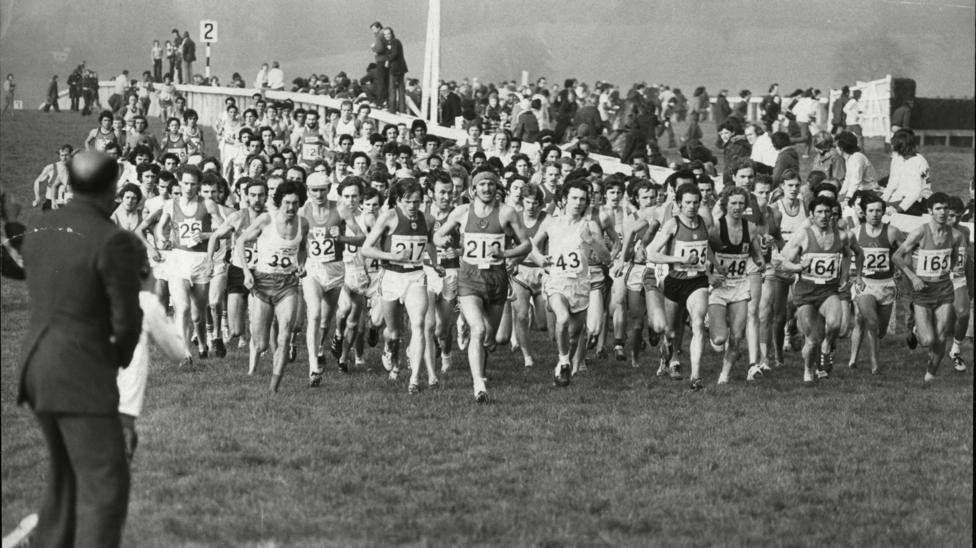 A black and white image of competitors running along the racecourse in 1976