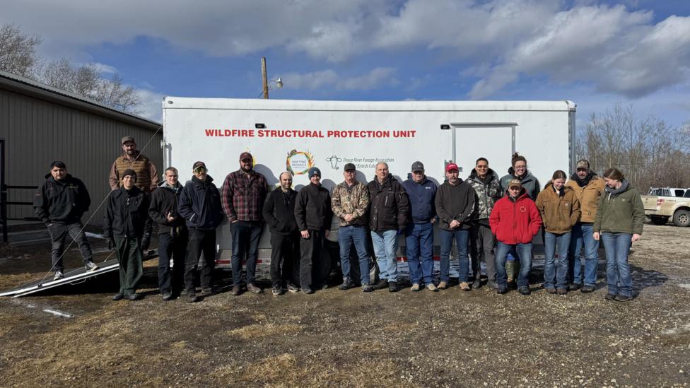 Members of the Northeast BC Rural Incident Management Team in front of a fire protection wagon they purchased using funds from donations and grants.