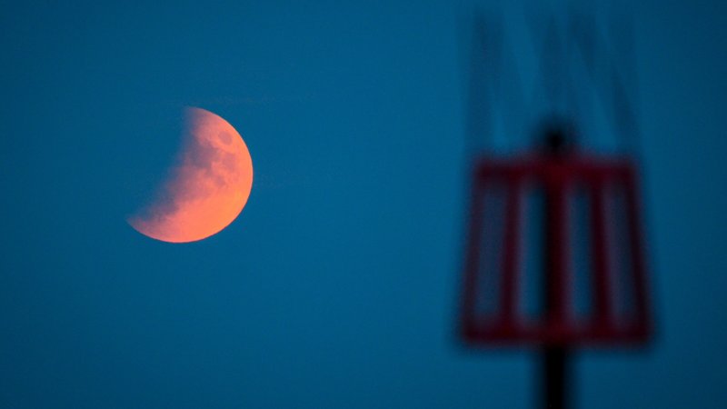 A picture of the eclipse behind a red tower. The image was taken in Sidmouth.