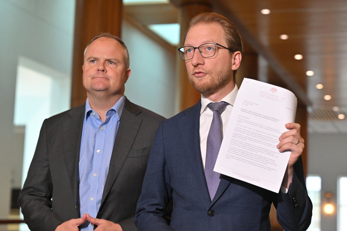 Ted O’Brien and James Paterson who is holding up a document