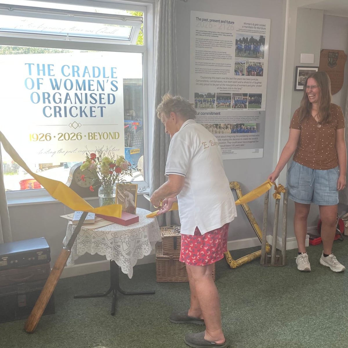 Raf Nicholson holds the ribbon as Enid Bakewell (left) cuts it to open the new heritage display in the Colwall Cricket Club clubhouse