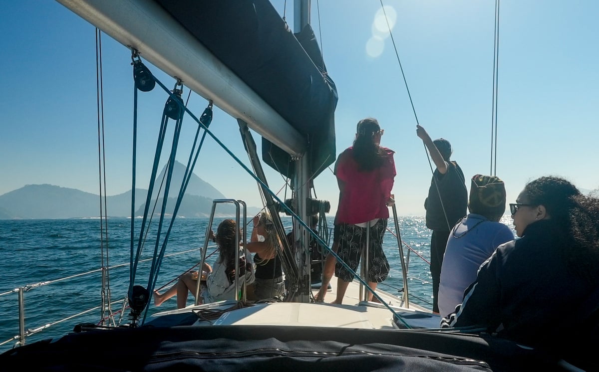 A group of six people on the deck of a sailing boat