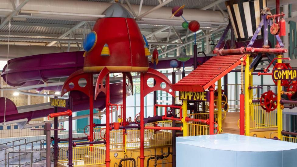 A bright, multi coloured array of slides above a swimming pool