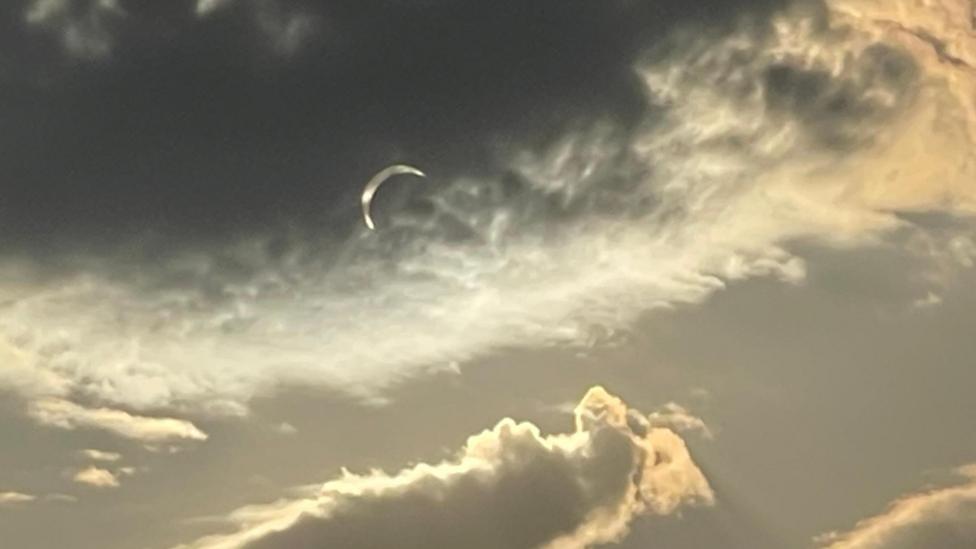 Cloudy sky reveals partial eclipse