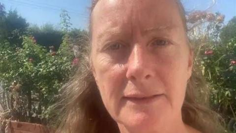 Councillor Lisa Scott in front of some greenery on a hot day