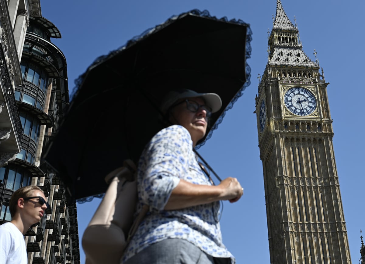 A woman holds a black umbrella, shielding herself from the sun. Big Ben Tower is in the background.