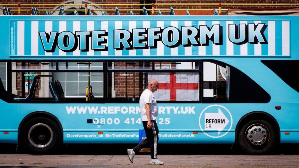 A person walks past a Reform UK campaign bus outside Clacton station in Clacton-on-Sea, Essex, Britain, 04 August 2026. Reform UK leader Nigel Farage will contest the Clacton by-election on 13 August in an effort to regain his seat after announcing his resignation as an MP on 07 July 2026 following a row over his financial affairs. Major UK political parties are not contesting the election, while satirical candidate Count Binface is polling second with support from around 20 percent of Clacton voters, according to a recent Survation poll. Clacton ahead of parliamentary by-election, Essex, United Kingdom - 04 Aug 2026