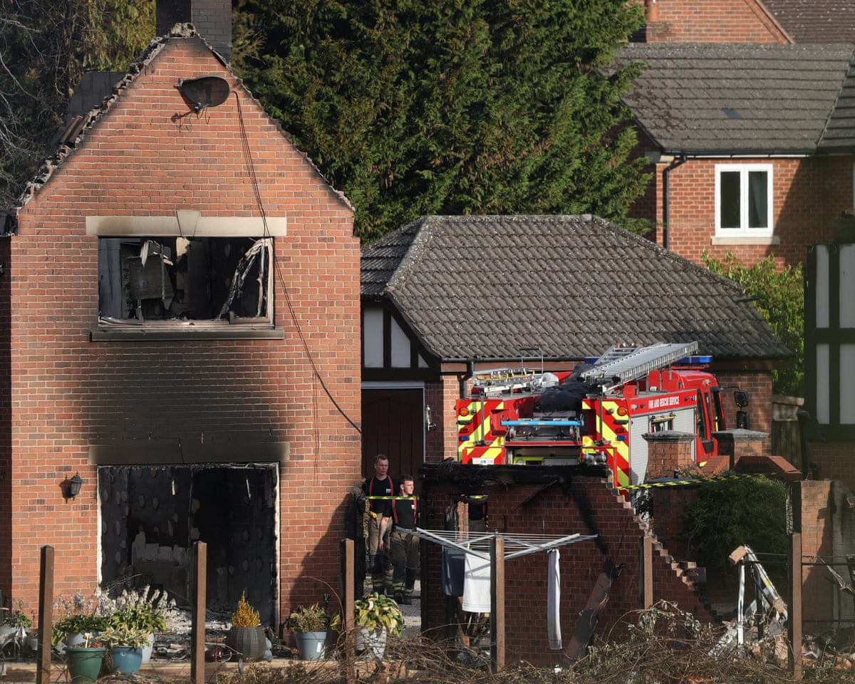 Firefighters inspect a burnt-out house following a large grass fire which spread to several homes yesterday during the hottest day of the year, in Stourbridge, West Midlands.