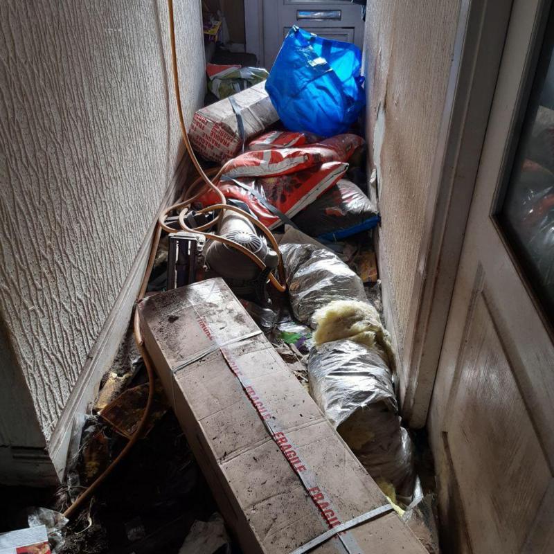 The hallway of a home filled with rubbish