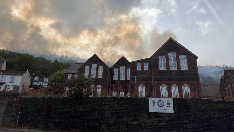 A fire seen behind some houses