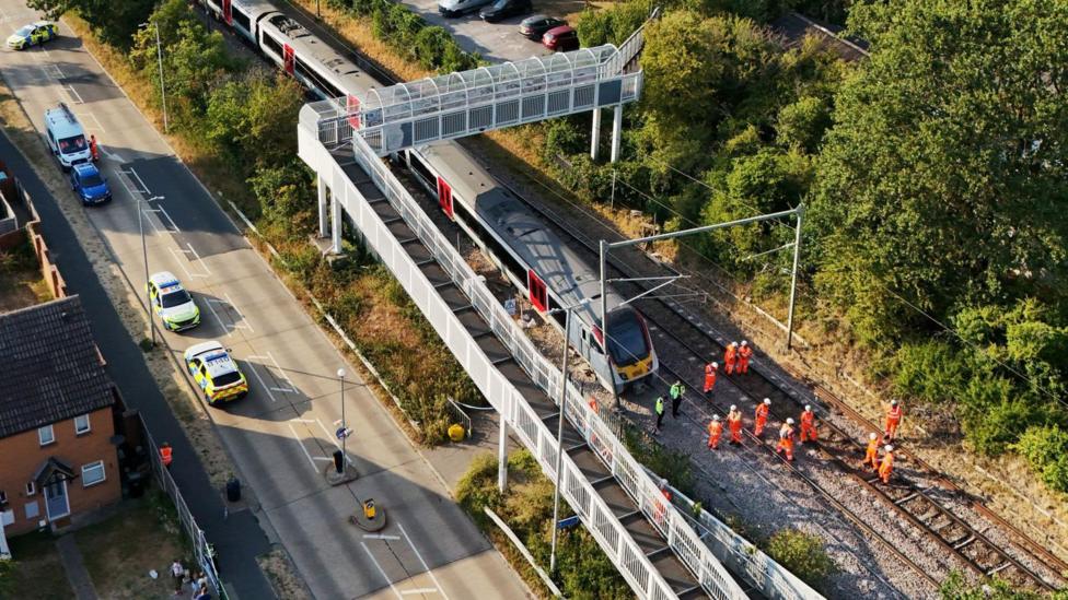 A drone image showing police and railway workers assessing the train and railway tracks.