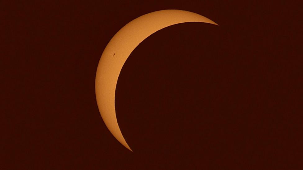 An orange crescent Sun as seen in the skies above St Mellion.