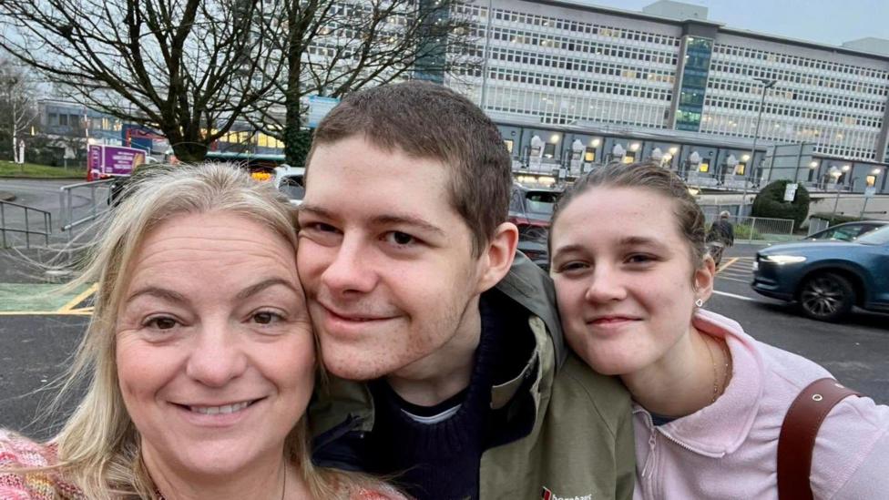 Cerys, Charlie and Judy at the University Hospital of Wales, Cardiff. They are smiling at the camera.