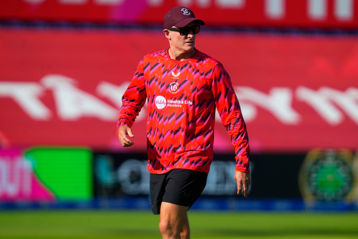 Mike Hussey in cap, red Welsh Fire top and dark shorts