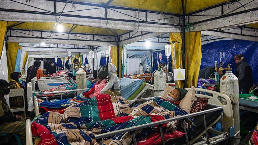 Earthquake victims are treated in a temporary medical tent due to fears of aftershocks, in front of the Ruteng hospital in Ruteng, Manggarai