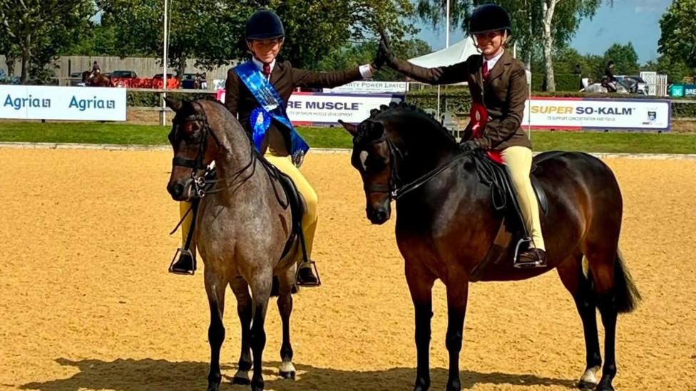 Esther (ar y chwith) a Millie yn ennill y wobr gyntaf a'r ail wobr yng nghategori Pretty Polly Show Hunter Pony yn y Royal International Horse Show. 