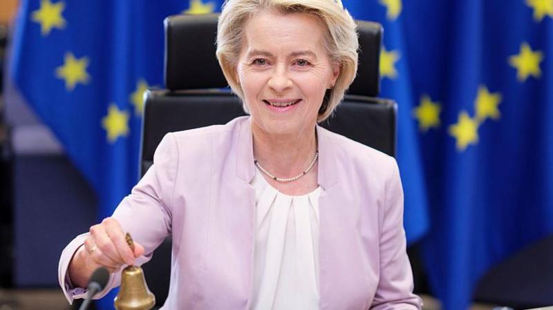President of the European Commission Ursula von der Leyen calls her colleagues prior to the weekly EU Commission College meeting by holding a small golden bell and smiling.