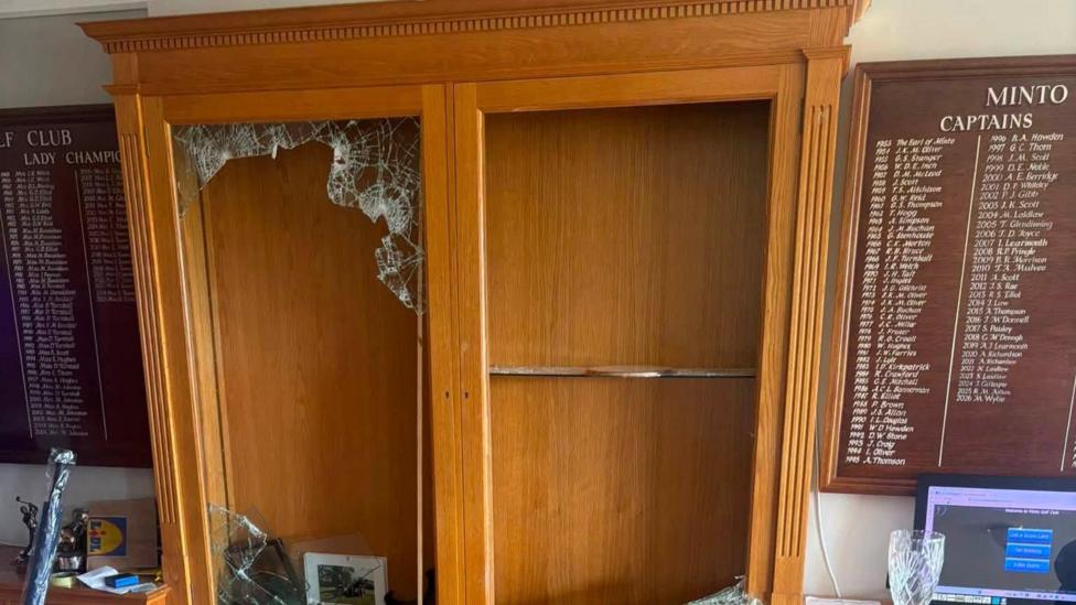 An empty trophy cabinet with a smashed glass front