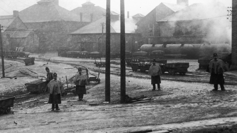 Police in helmets and cloaks to protect against the elements keep guard in the grounds of a colliery
