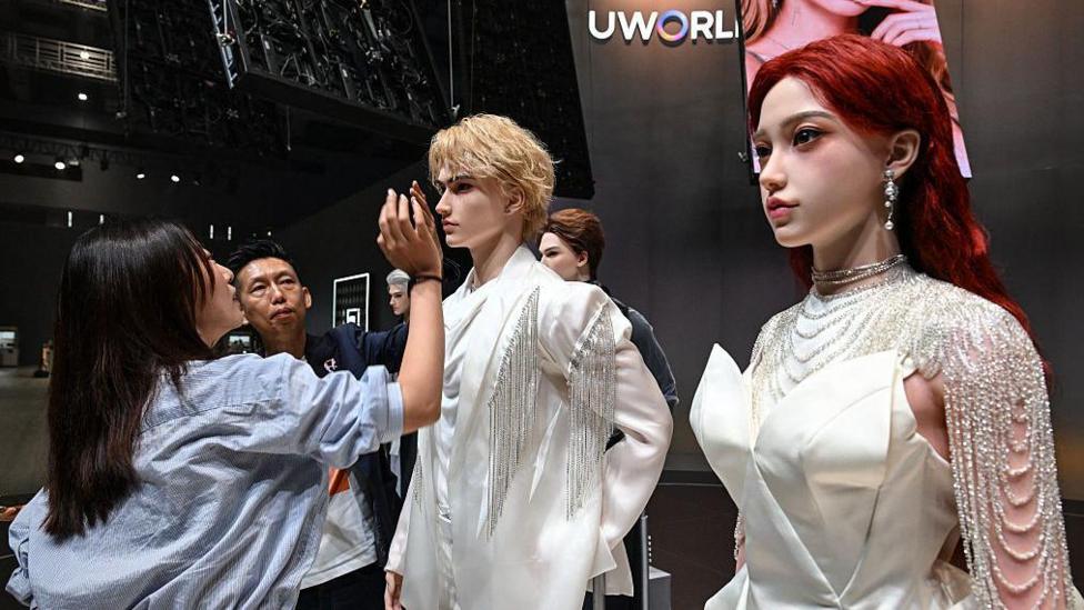 A woman inspects a display showcasing UBTech's lifelike humanoid robots