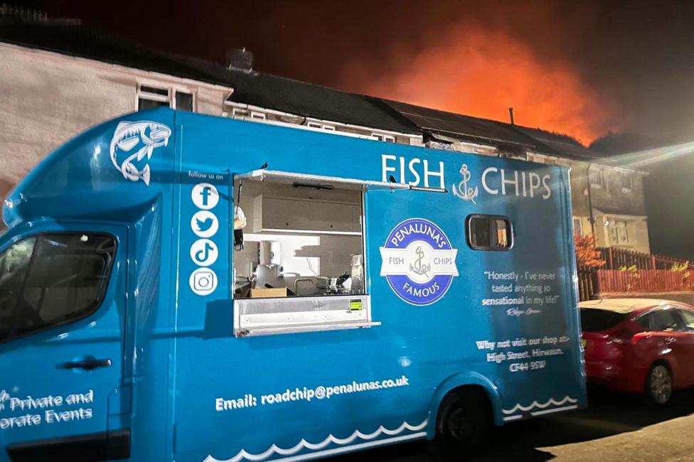 Penaluna fish and chip van from Hirwaun parked on a street as firefighters tackle a wildfire blaze on the nearby Rhigos mountain