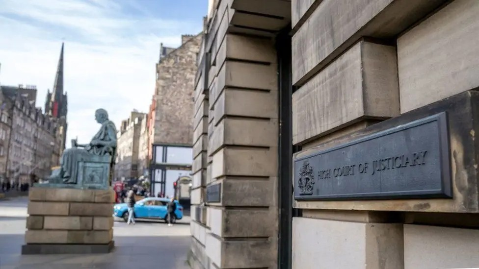 A view from the street of the High Court in Edinburgh. A sign saying High Court of Justiciary is visible.